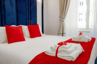 a white bed with red pillows and towels on it at Historical Center in Rome