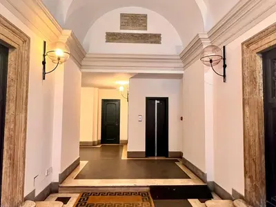 a hallway with white walls and a black door at Historic Fresco Suite Rome Colosseum Boutique Stay in Rome
