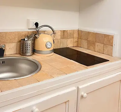 a kitchen counter with a sink and a tea kettle at Historic Fresco Suite Rome Colosseum Boutique Stay in Rome