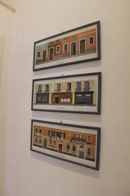 three framed pictures of a building hanging on a wall at casa vacanze Borgo San Lazzaro in Rome