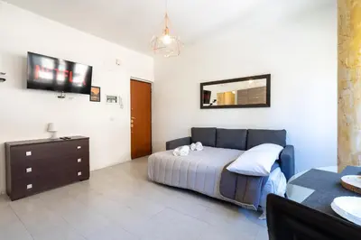 a bedroom with a bed and a dresser and a mirror at NEW OPENING! Close to St Peter & Free Netflix in Rome