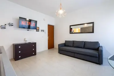a living room with a couch and a mirror at NEW OPENING! Close to St Peter & Free Netflix in Rome
