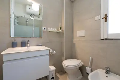 a bathroom with a toilet and a sink and a mirror at NEW OPENING! Close to St Peter & Free Netflix in Rome