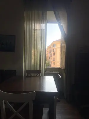 a table and chairs in a room with a window at Sunny apartment in central Rome in Rome