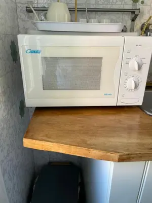 a microwave sitting on top of a wooden table at Sunny apartment in central Rome in Rome