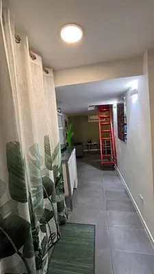 a hallway with a kitchen and a red ladder at la casa di lola in Rome