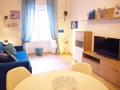 a living room with a blue couch and a table at Blue House Termini-Colosseo in Rome