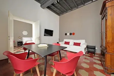 a dining room with a table and red chairs at Pantheon Authentic and Modern Apartment in Rome