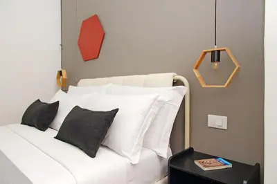 a bedroom with a white bed with black pillows at Pantheon Authentic and Modern Apartment in Rome