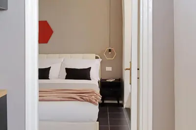 a bedroom with a large white bed and a table at Pantheon Authentic and Modern Apartment in Rome