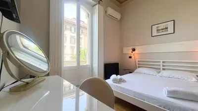 a bedroom with a bed with a mirror and a window at Casa Daria in Rome
