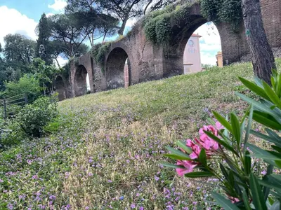 an old building on top of a hill with flowers at Archouse - Elegant apartment a 10 min dal Colosseo in Rome