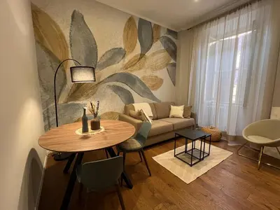 a living room with a table and a couch at Archouse - Elegant apartment a 10 min dal Colosseo in Rome