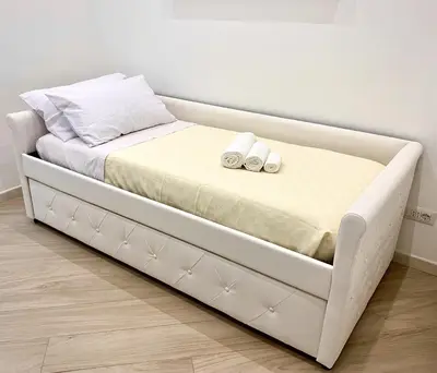 a large white bed with two slippers on it at Appartamento metro Ponte Lungo in Rome
