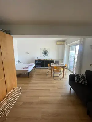 a living room with a couch and a table at Bright and Cozy Studio Apartment near Trastevere Station in Rome