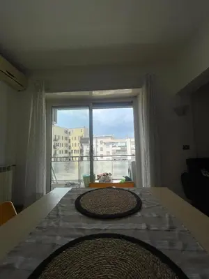 a bedroom with a large window with a view of a city at Bright and Cozy Studio Apartment near Trastevere Station in Rome
