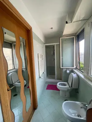 a bathroom with two toilets and a sink at Bright and Cozy Studio Apartment near Trastevere Station in Rome