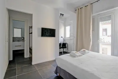 a white bedroom with a bed and a desk at Modern house near Trastevere in Rome