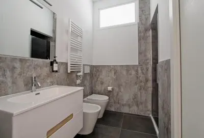 a bathroom with a sink and a toilet and a window at Modern house near Trastevere in Rome