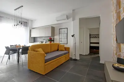 a living room with a yellow couch and a table at Modern house near Trastevere in Rome