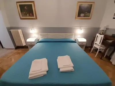 a blue bed with two white towels on it at Il Sole di Roma in Rome
