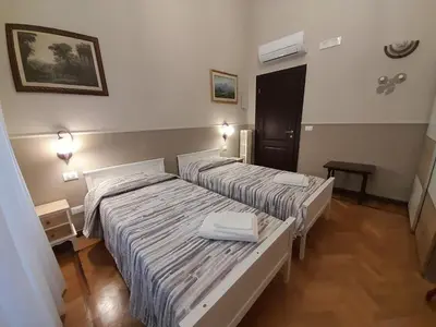 two beds in a hotel room with two white beds at Il Sole di Roma in Rome