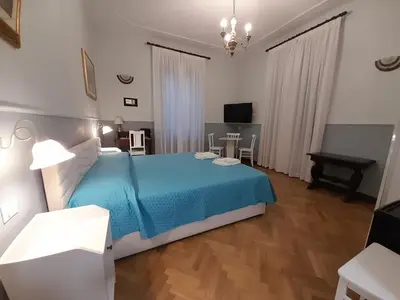 a bedroom with a blue bed and a piano at Il Sole di Roma in Rome