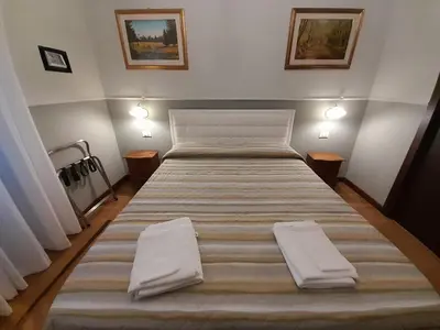 a large bed in a bedroom with two pillows on it at Il Sole di Roma in Rome
