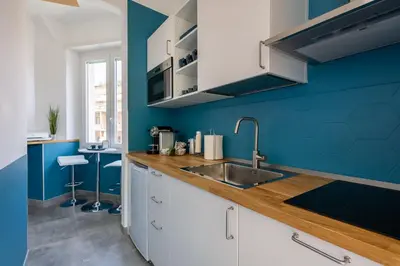a kitchen with a sink and a blue wall at Cornelia Vatican Suites in Rome