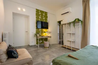 a living room with a couch and a tv on a wall at Cornelia Vatican Suites in Rome