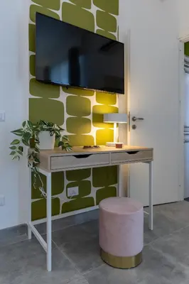 a desk with a tv on a wall at Cornelia Vatican Suites in Rome