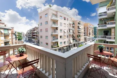 a balcony with tables and chairs and buildings at Cornelia Vatican Suites in Rome