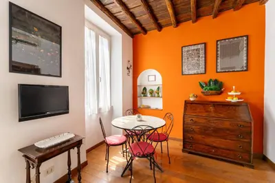 a dining room with a table and chairs and a desk at Domus Leopardo, Typical Trastevere Flat in Center in Rome