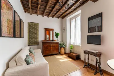 a living room with a couch and a tv at Domus Leopardo, Typical Trastevere Flat in Center in Rome