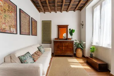 a living room with a white couch and a table at Domus Leopardo, Typical Trastevere Flat in Center in Rome