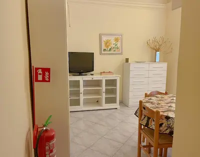 a room with a table and a television and a dining room at MARIA TERESA Apartment II - Refined Living with Excellent City Links - Via Alessandria - QUARTIERE TRIESTE in Rome