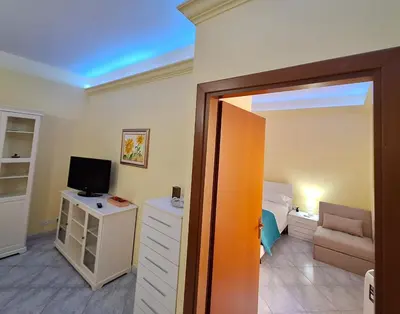 a room with a bedroom with a bed and a television at MARIA TERESA Apartment II - Refined Living with Excellent City Links - Via Alessandria - QUARTIERE TRIESTE in Rome