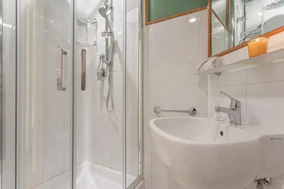 a white bathroom with a shower and a sink at Key Apartment Trastevere in Rome