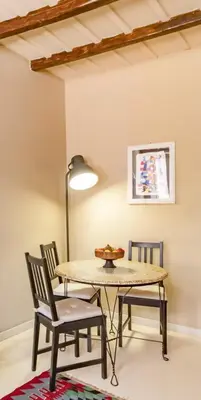 a table and chairs in a room with a lamp at Flaminia Luxury Hideaway in Rome