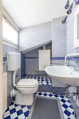 a blue and white bathroom with a toilet and a sink at Flaminia Luxury Hideaway in Rome