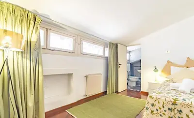 a bedroom with a bed and a bathroom with windows at Flaminia Luxury Hideaway in Rome