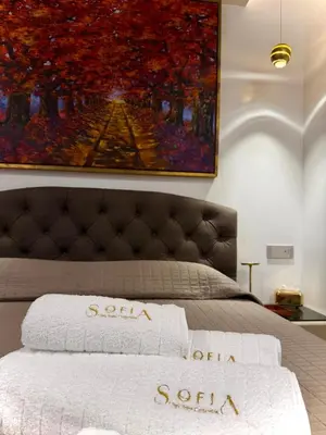 a bedroom with a bed with a painting on the wall at SOFIA Ultra Suite Collection in Rome