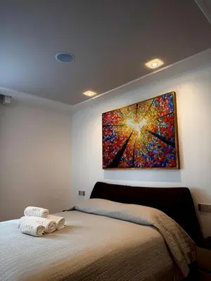 a bedroom with a bed with a painting on the wall at SOFIA Ultra Suite Collection in Rome