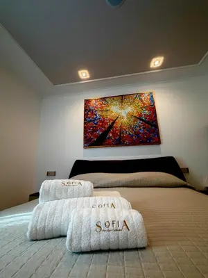 a bedroom with two beds and a painting on the wall at SOFIA Ultra Suite Collection in Rome