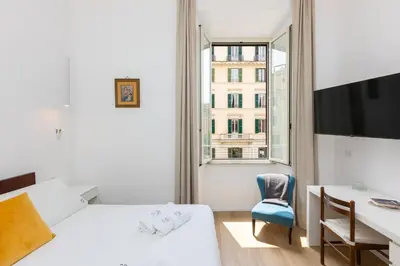 a bedroom with two beds and a desk and a window at Cola di Rienzo Apartment by Rental in Rome in Rome