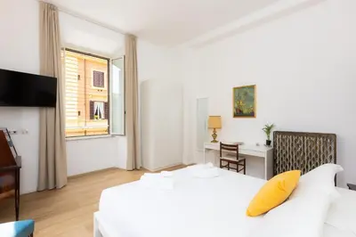 a bedroom with a white bed and a yellow pillow at Cola di Rienzo Apartment by Rental in Rome in Rome
