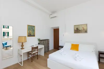 a bedroom with a white bed and a desk and a chair at Cola di Rienzo Apartment by Rental in Rome in Rome