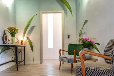 a living room with a chair and a vase of flowers at 18 Vatican Penthouse in Rome
