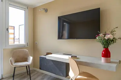 a room with a desk with a television and a chair at 18 Vatican Penthouse in Rome
