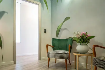 a room with a chair and a vase with flowers at 18 Vatican Penthouse in Rome